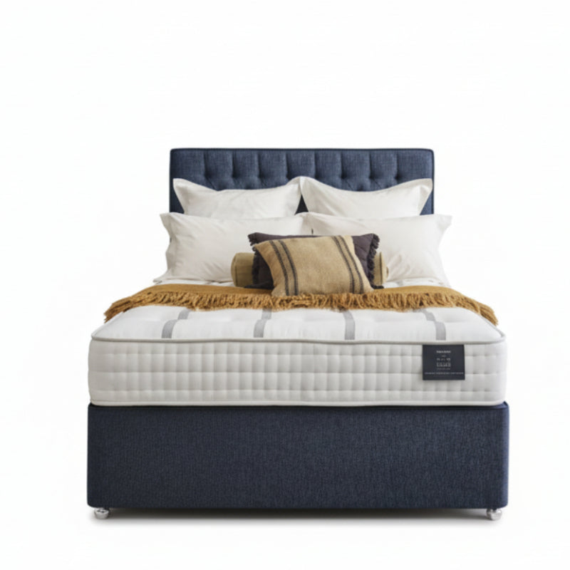 Bed with white mattress, blue headboard, and pillows on a white background