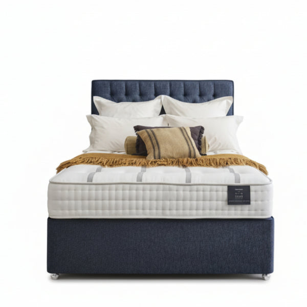 Bed with white mattress, blue headboard, and pillows on a white background