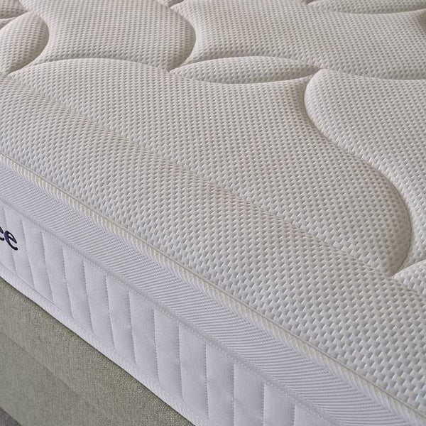 Close-up of a white mattress with 'Sleepeezee' branding on a bed.