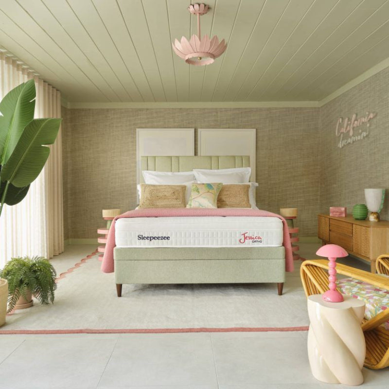 Modern bedroom with a bed, desk, and decorative items.