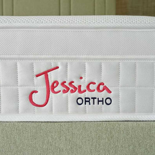 White mattress with 'Jessica Ortho' branding on a green bedspread.