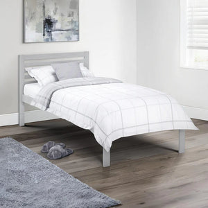 Bedroom with a gray bed frame and white bedding, featuring a gray rug and slippers.