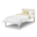 White bed with a yellow blanket on a white background