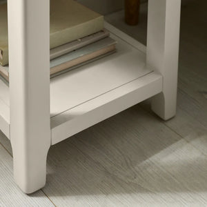 Beige side table with a glass shelf on a wooden floor