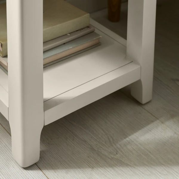 Beige side table with a glass shelf on a wooden floor