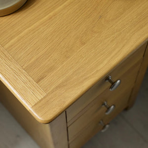 Wooden cabinet with a visible grain pattern and metal handles.