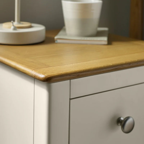 Wooden surface with a lamp and cup on top of a cabinet.