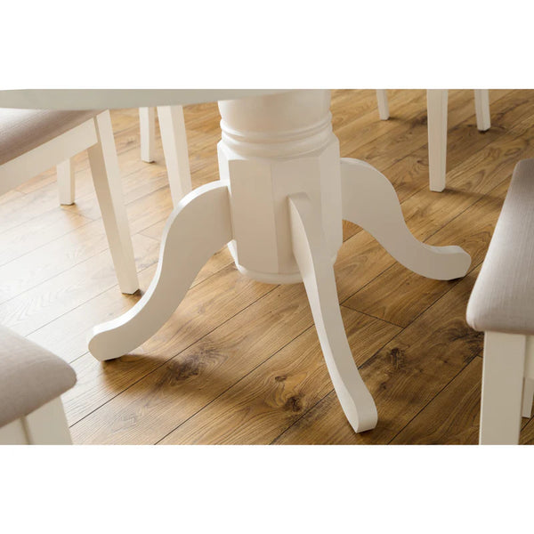 White dining table with curved legs on a wooden floor