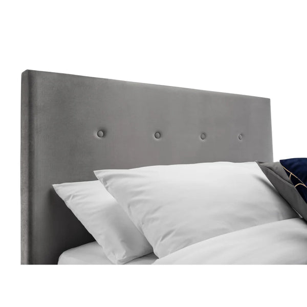 Gray upholstered headboard with white pillows on a white background