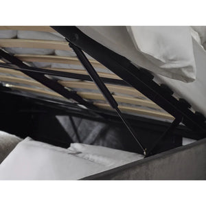 Close-up of a bed with a black metal frame and white bedding.