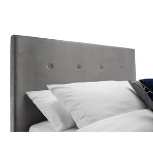 Gray upholstered headboard with white pillows on a white background