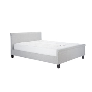 Gray upholstered bed with white mattress on a white background