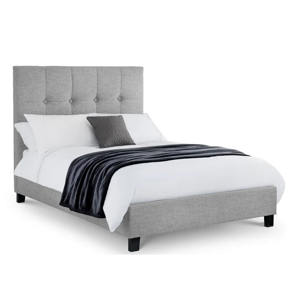 Gray upholstered bed with white bedding and a gray pillow on a white background