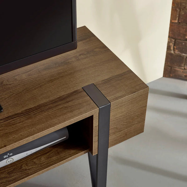 Wooden TV stand with a black metal leg in a room setting