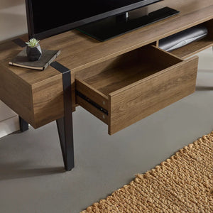 Wooden TV stand with a drawer, television, and decorative items on a neutral background.