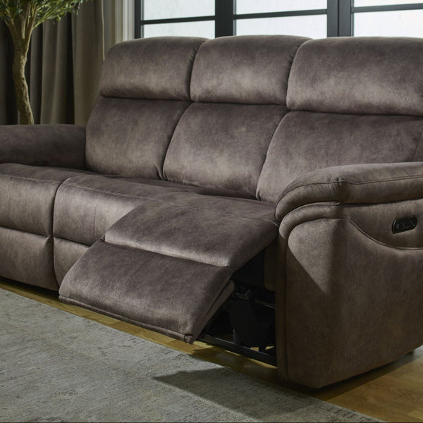 Gray reclining sofa in a living room with large windows and a plant.