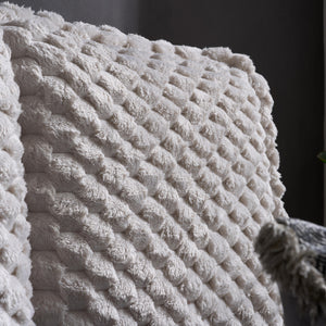 Close-up of a textured white bed with a dark background