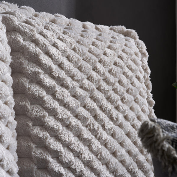 Close-up of a textured white bed with a dark background