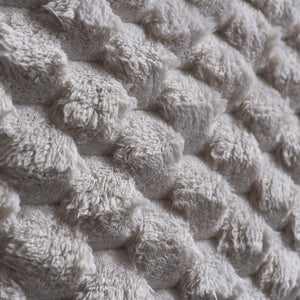 Close-up of textured beige fabric with a knitted pattern