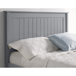 Gray wooden headboard with white bedding and a blue pillow.