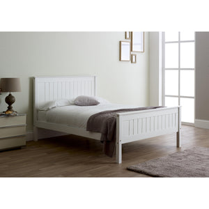 White wooden bed in a room with a lamp and window