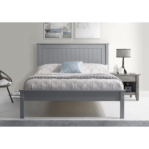 Gray wooden bed in a bedroom setting with a lamp and chair.