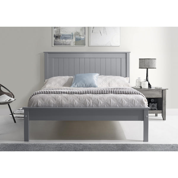 Gray wooden bed in a bedroom setting with a lamp and chair.