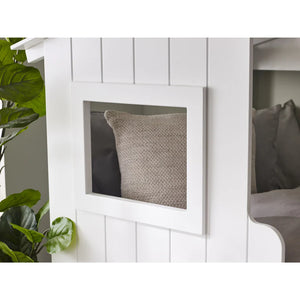 Gray pillow in a white wooden cabinet with a plant on the side