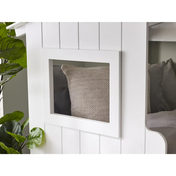 Gray pillow in a white wooden cabinet with a plant on the side