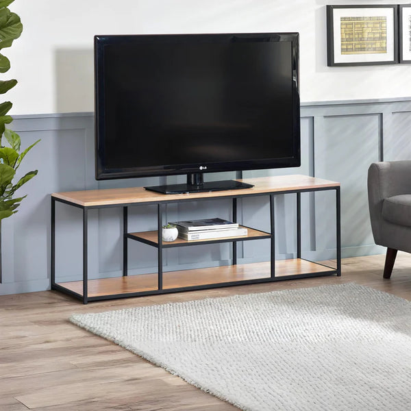 TV on a wooden stand in a living room setting with a plant and chair.