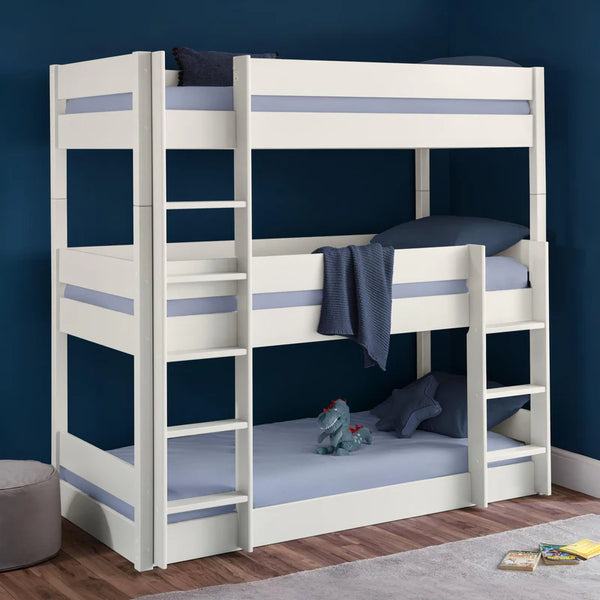 White bunk bed with blue accents in a room with a blue wall.