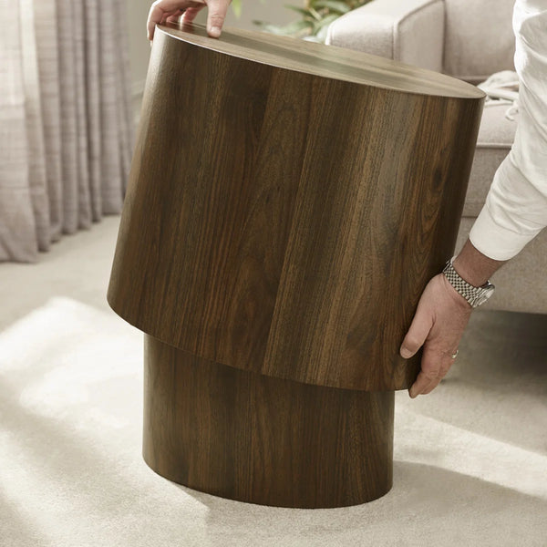 Wooden side table being held by a person in a living room setting