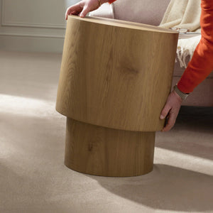 Wooden side table being held by a person in a home setting