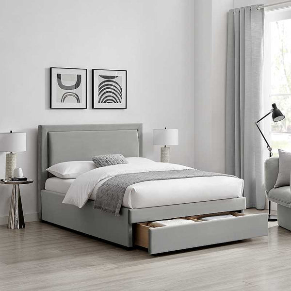 Gray upholstered bed with storage drawers in a bedroom setting.