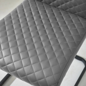 GREY DINING CHAIR , CLOSE UP OF THE SEAT AND STITCHING ON A WHITE BACKGROUND