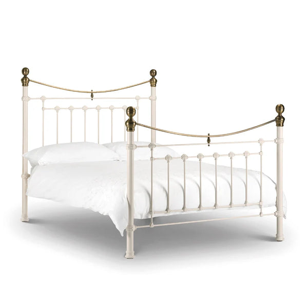 White metal bed with brass accents on a white background