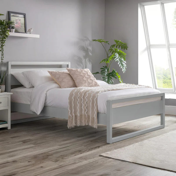 Bedroom with a gray bed frame, white bedding, and decorative pillows.
