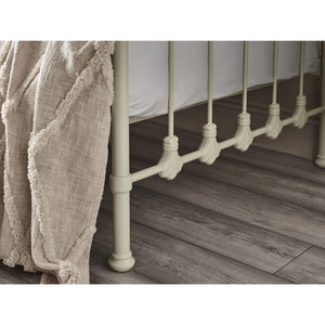 Close-up of a metal bed frame with wooden flooring