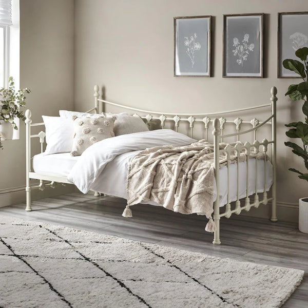Neatly made bed with decorative pillows and a blanket in a bedroom setting.