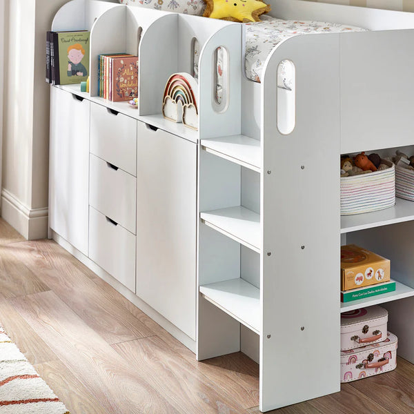 White children's bed with storage drawers and shelves in a room setting.