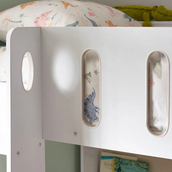 Children's bed with dinosaur-themed bedding and white headboard