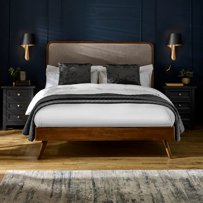 Bed with wooden frame and upholstered headboard on a white background