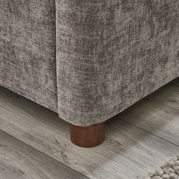 Grey chenille bed frame with wooden legs on a wooden floor