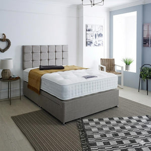 Bedroom with a gray upholstered bed and white mattress