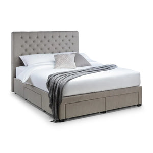 Gray upholstered bed with white bedding and a gray throw blanket on a white background