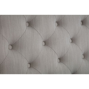 Close-up of a tufted gray headboard with button details.
