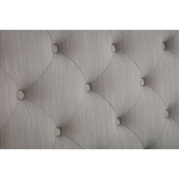 Close-up of a tufted gray headboard with button details.