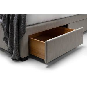 Gray upholstered bed with an open wooden drawer on a white background