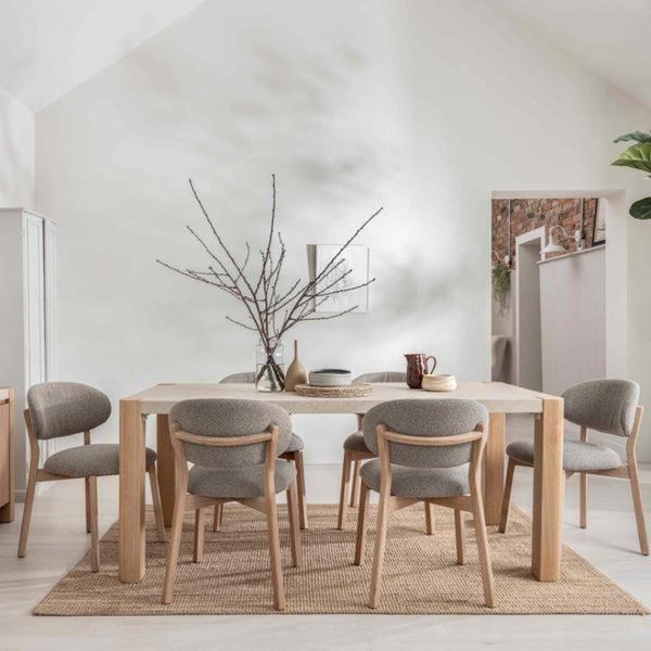 Dining area with wooden table and chairs in a bright room.