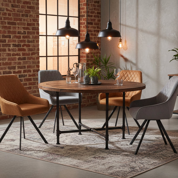 Dining area with a wooden table and modern chairs in a room with brick walls and pendant lights.